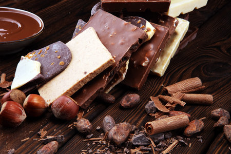 Chocolate bars on table with chocolate tower. Chocolate and nuts and choco swirl