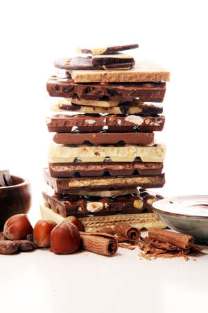 Chocolate bars on table with chocolate tower. Chocolate and nuts and choco swirlの写真素材