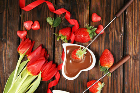 Valentine Chocolate fondue melted with fresh strawberries and dark and white chocolate. Tublips and red sugar heartsの写真素材