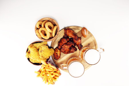 chicken wings, fries, beer and onion rings for football on a table. Great for Bowl football Gameの写真素材