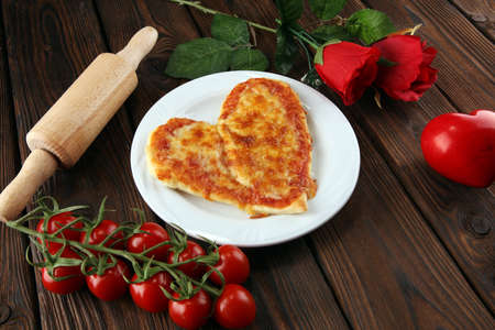 Valentines day pizza in heart shape on dark rustic wooden background.  Valentine heart pizza foodの写真素材