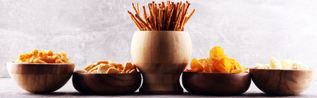 Salty snacks. Pretzels, chips, crackers in wooden bowls. Unhealthy products. food bad for figure,...