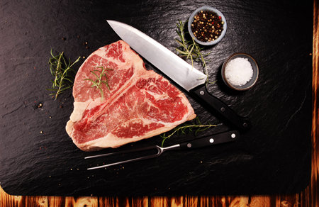 Raw T-bone steak on stone plate. bbq bone steak set