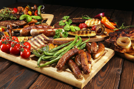 Assorted delicious grilled meat with vegetable and herbs on rustic table