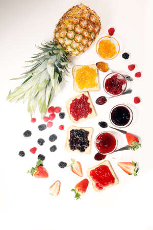 assortment of jams, seasonal berries, plums, mint and fruits with strawberry and currantsの写真素材