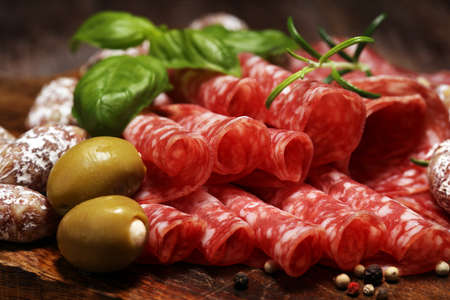 thinly sliced salami on a wooden texture on the backgroundの写真素材