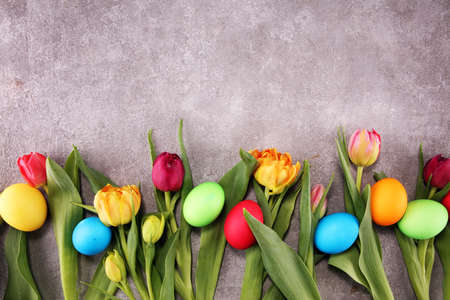 Easter eggs and colorful tulips on rustic tableの写真素材