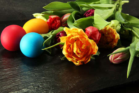 Easter eggs and colorful tulips on rustic tableの写真素材