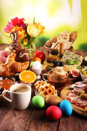 breakfast on table with bread buns, croissants, coffe and donutsの写真素材