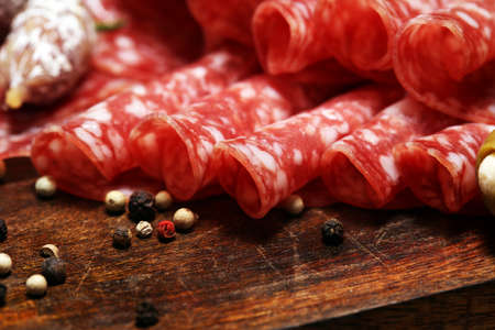 thinly sliced salami on a wooden texture on the backgroundの写真素材