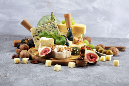 Cheese plate served with figs, various cheese on a platter on wooden tableの写真素材