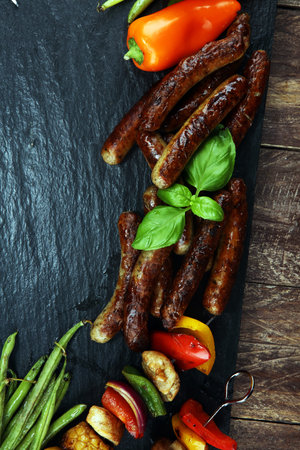 Assorted delicious grilled meat and skewer with vegetable and herbs on rustic table