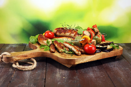Assorted delicious grilled meat with vegetable on a barbecue and grilled pork shish or kebab on...