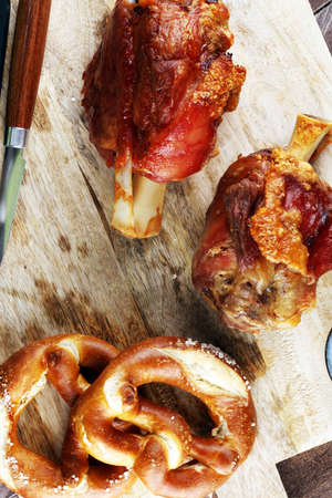 Traditional German cuisine, Schweinshaxe roasted ham hock. pretzels Bavarian specialties. Oktoberfest backgroundの写真素材