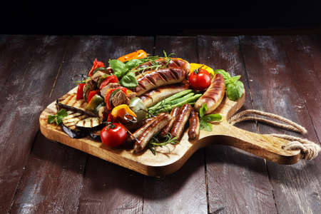 Assorted delicious grilled meat with vegetable on a barbecue and grilled pork shish or kebab on skewers with vegetables.の写真素材