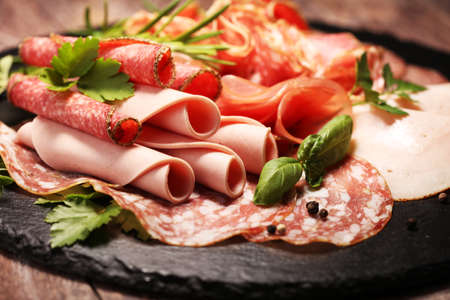 Food tray with delicious salami, pieces of sliced ham, sausage - Meat platter with selectionの写真素材