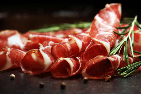 Italian sliced cured coppa with spices. Raw ham. Crudo or jamon on woodの写真素材