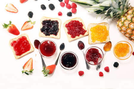 assortment of jams, seasonal berries, plums, mint and fruits with strawberry and currantsの写真素材