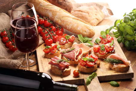 antipasto various appetizer. Cutting board with prosciutto, salami, coppa, cheese,bread sticks and olives on dark woodenの写真素材