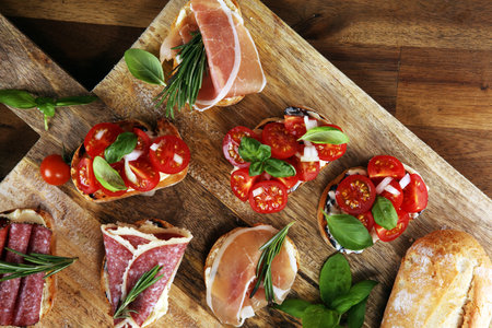 antipasto various appetizer. Cutting board with prosciutto, salami, coppa, cheese,bread sticks and...
