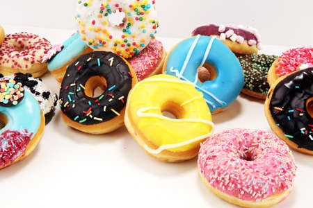 assorted donuts with chocolate frosted, pink glazed and sprinkles donuts.の写真素材