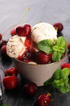 Cherry ice cream scoop with fresh cherries on a rustic background