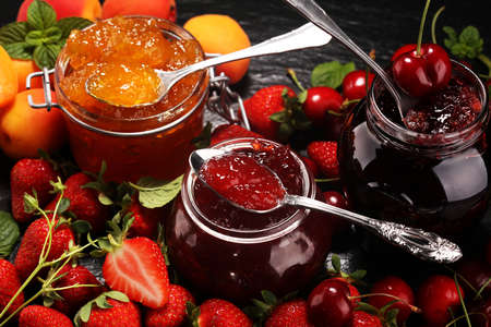 assortment of jams, seasonal berries, apricot, mint and fruits. marmalade or confitureの写真素材