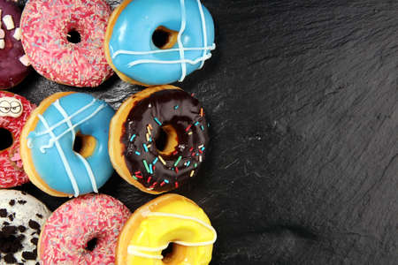 assorted donuts with chocolate frosted, pink glazed and sprinkles donuts.の写真素材