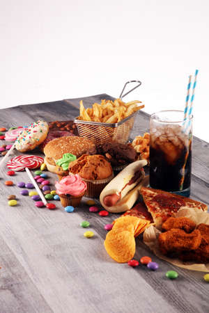 Unhealthy products. food bad for figure, skin, heart and teeth. Assortment of fast carbohydrates food with fries and colaの写真素材