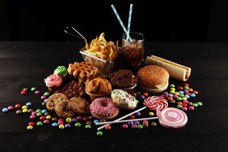 Unhealthy products. food bad for figure, skin, heart and teeth. Assortment of fast carbohydrates food with fries and colaの写真素材