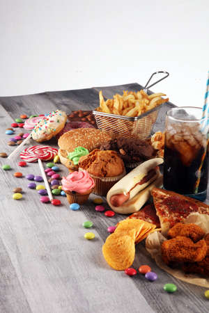 Unhealthy products. food bad for figure, skin, heart and teeth. Assortment of fast carbohydrates food with fries and colaの写真素材