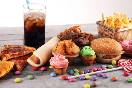 Unhealthy products. food bad for figure, skin, heart and teeth. Assortment of fast carbohydrates food with fries and colaの写真素材