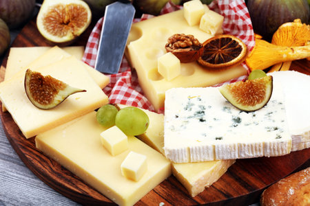 Cheese platter with different cheese and grapes and figs