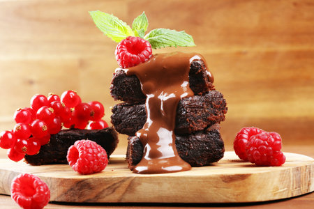 chocolate brownie cake dessert with raspberries and spices on a wooden background.の写真素材