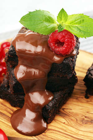 chocolate brownie cake dessert with raspberries and spices on a wooden background.の写真素材
