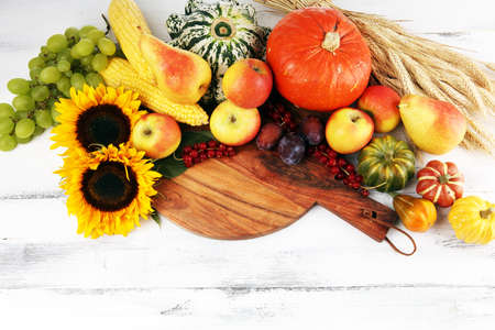 Autumn nature concept. Fall fruit and vegetables on wood. Thanksgiving dinner with sunflowerの写真素材