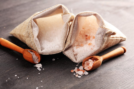 Sea salt and himalayan in burlap. Crystals of salt on rustic tableの写真素材