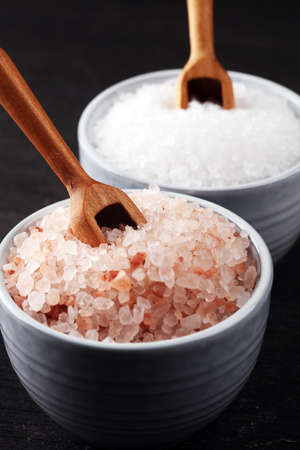 Sea salt and himalayan in bowl. Crystals of salt on rustic tableの写真素材