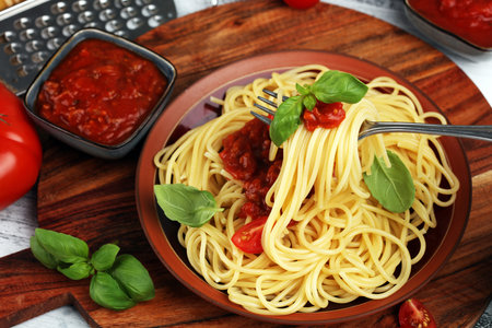 Plate of delicious spaghetti Bolognaise or Bolognese with savory minced beef and tomato sauce garnished with parmesan cheese