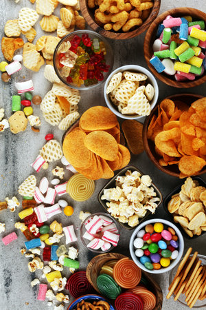 Salty snacks. Pretzels, chips, crackers and candy sweets. Unhealthy products. food bad for figure, skin, heart and teeth. Assortment of fast carbohydrates food.の写真素材