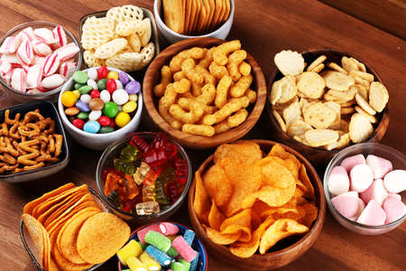 Salty snacks. Pretzels, chips, crackers and candy sweets. Unhealthy products. food bad for figure, skin, heart and teeth. Assortment of fast carbohydrates food.の写真素材