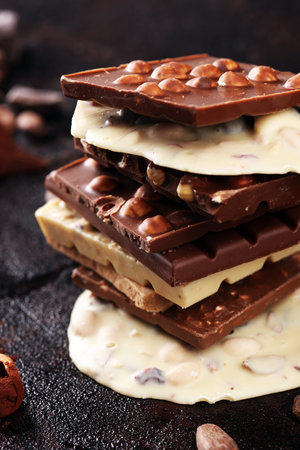 Chocolate bars on a rustic background with chocolate tower