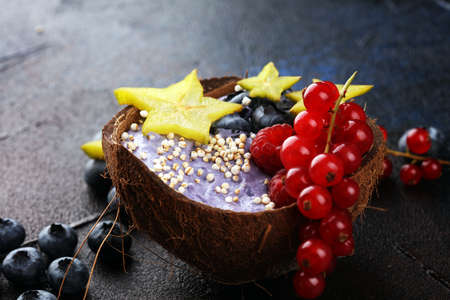 Healthy homemade raw vegan banana and berry ice cream (icecream, nicecream) topped with organic blackberries and blueberries on tableの写真素材