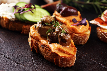 Assorted bruschetta with various toppings. Appetizing bruschetta or brie crostini. Variety of small sandwiches. Mix bruschettaの写真素材