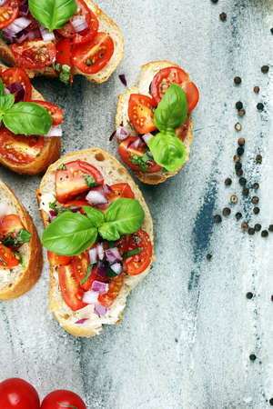 fresh tomato bruschetta. italian food appetizer with basil on rustic tableの写真素材
