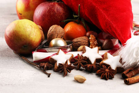 christmas cookies and santa had with spieses, nuts and fruits on tableの写真素材