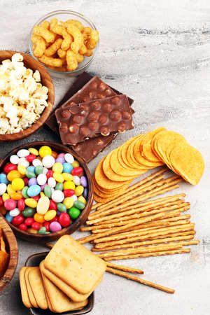 Salty snacks. Pretzels, chips, crackers in wooden bowls. Unhealthy products. food bad for figure, skin, heart and teeth. Assortment of fast carbohydrates food. の写真素材