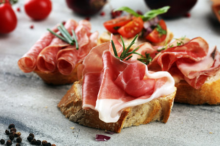 Assorted bruschetta with various toppings. Appetizing bruschetta or crudo crostini. Variety of small...