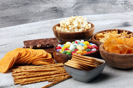 Salty snacks. Pretzels, chips, crackers in wooden bowls. Unhealthy products. food bad for figure,...