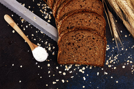bread cutted on board from above. Kitchen or bakery poster design on dark.